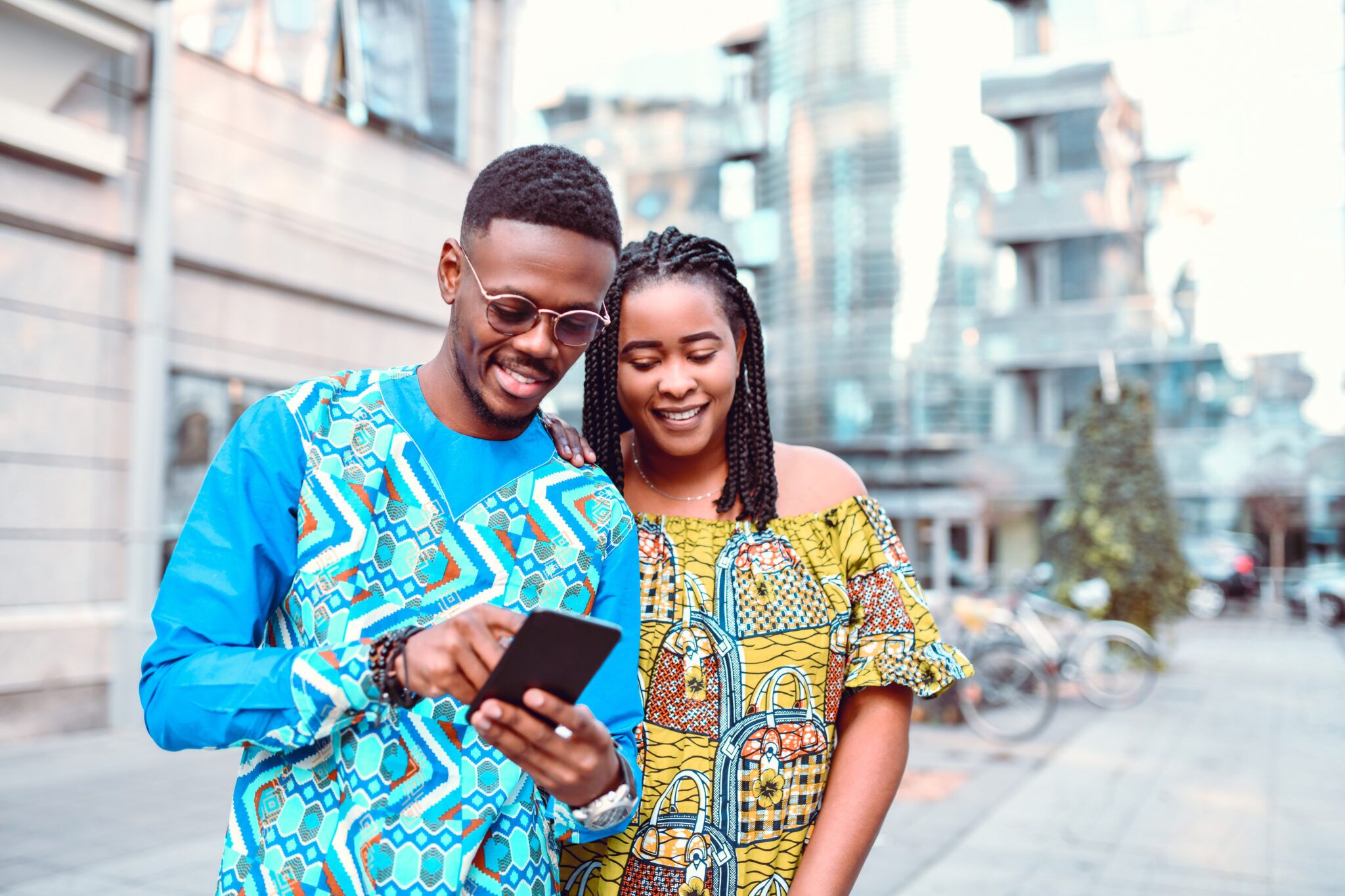 African couple checking their smartphone in modern african city